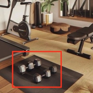 Home gym with a treadmill, exercise bike, and weight bench. A red box highlights a mismatched pair of dumbbells on the floor mat, an AI-generation tell.